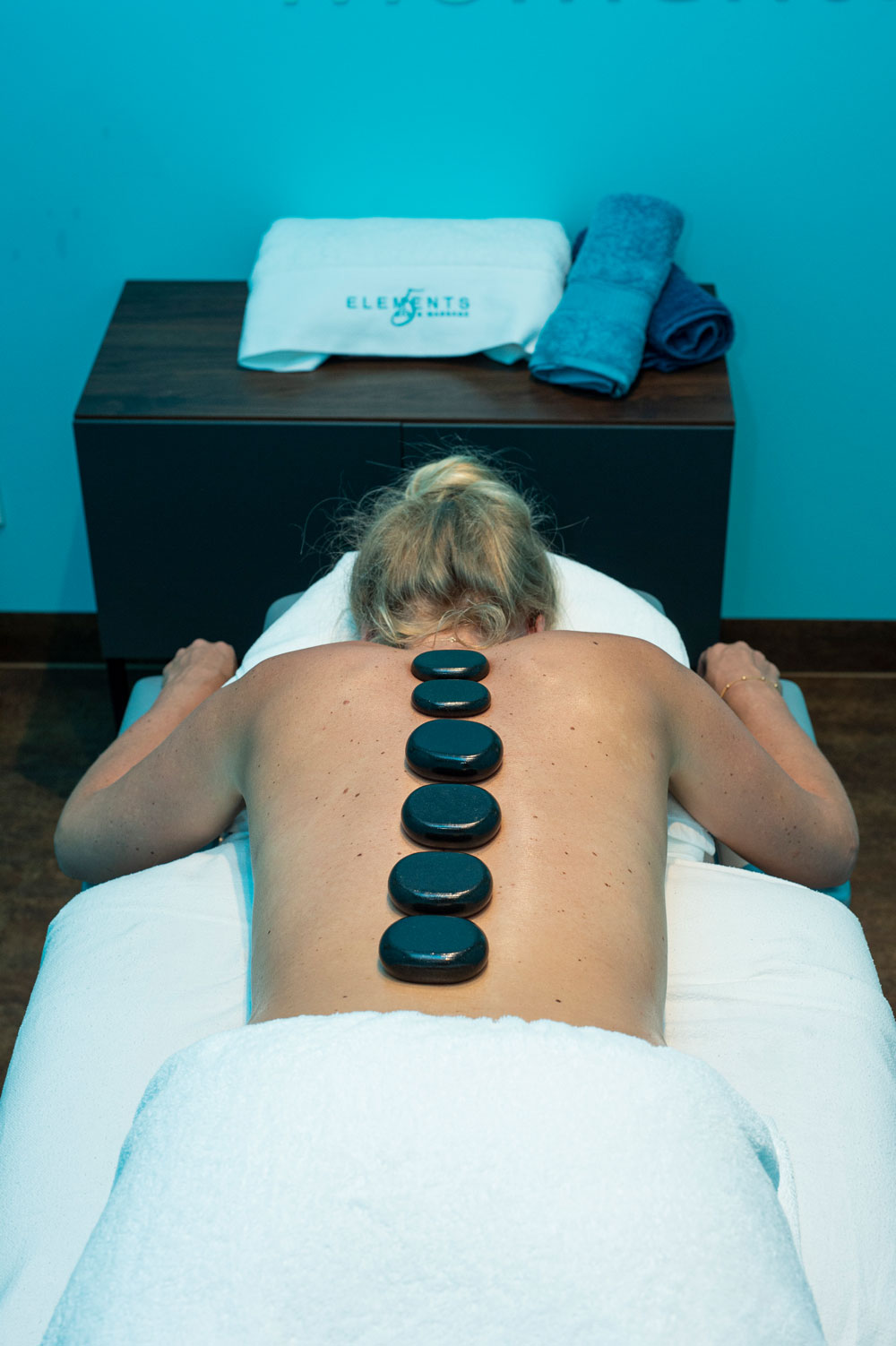 Hot Stone Massage - Steine auf der Wirbelsäule verteilt